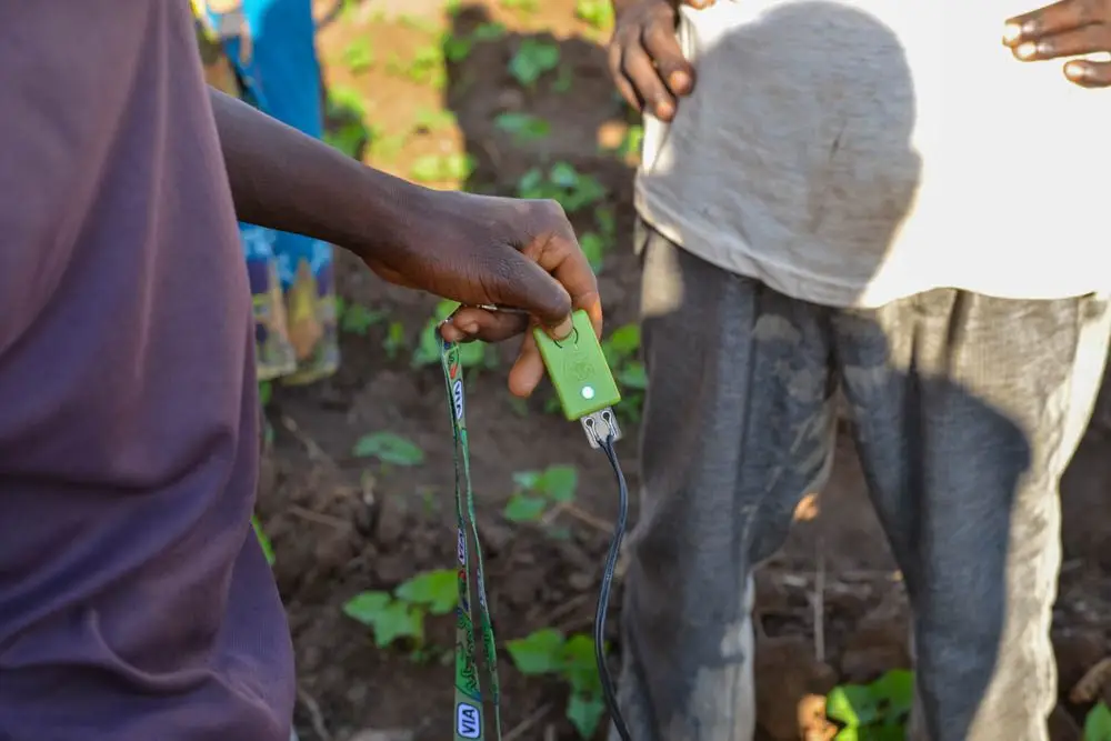 A green Chameleon One reader held in a farmer's hand at Nzangaulinazo irrigation scheme, Malawi